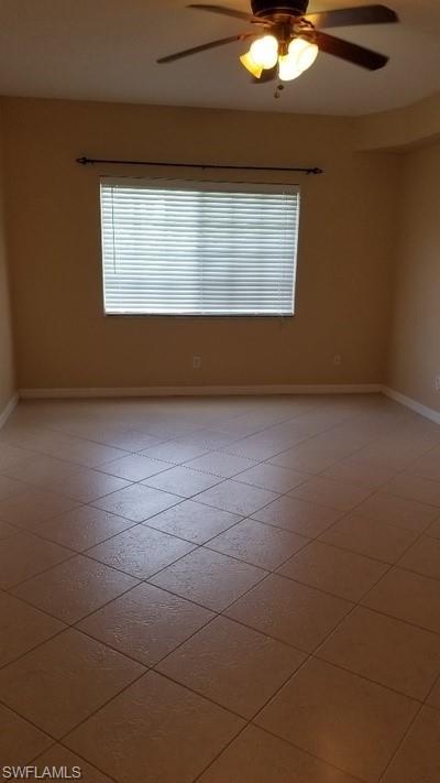 Tiled flooring, ceiling fan with integrated lighting, and a window with blinds