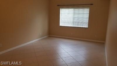 Tile flooring, neutral wall tones, white trim, and a window with horizontal blinds