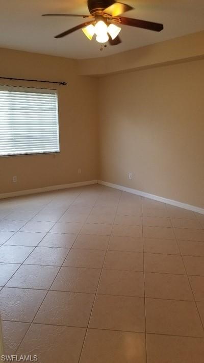 Tiled flooring, window with blinds, ceiling fan with integrated lighting, and neutral wall tones