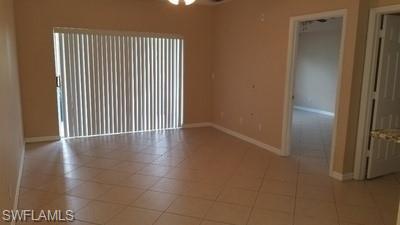 Tile flooring, sliding glass door with vertical blinds, and a ceiling fan