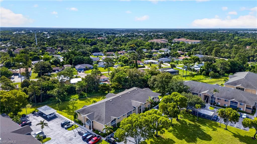 Aerial perspective showcasing a multi-unit property with ample surface parking and covered parking structures