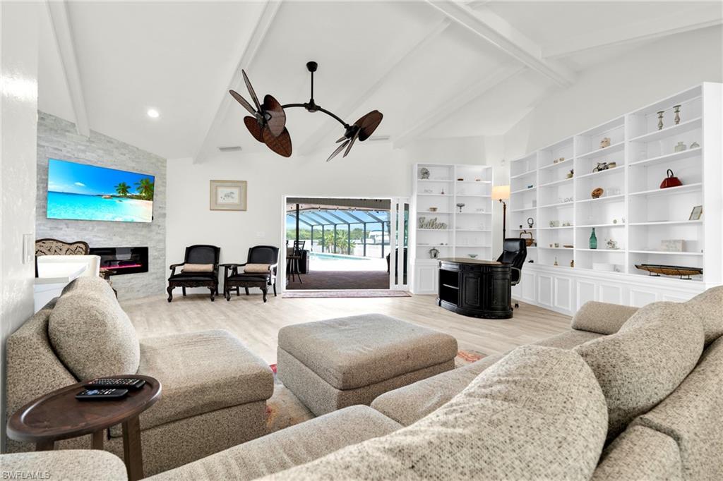 This Oversized Living Room Comes With An Elephant Ear Ceiling Fan, Extra Bookshelves, A Tripple Hurricane Slider That Leads Out To A Covered Lanai/Pool Area, And A Stone Covered Fireplace.