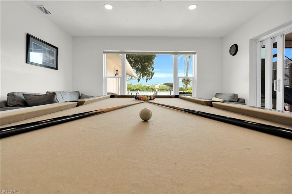 The Family Room/Game Room Has A Stone Walled Fireplace, Triple Hurricane Slider That Leads Out To The Covered Lanai/Pool Area, And A Large Picture Window With An Amazing View Of The River!