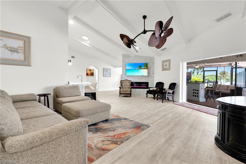This Oversized Living Room Comes With An Elephant Ear Ceiling Fan, Extra Bookshelves, A Tripple Hurricane Slider That Leads Out To A Covered Lanai/Pool Area, And A Stone Covered Fireplace.