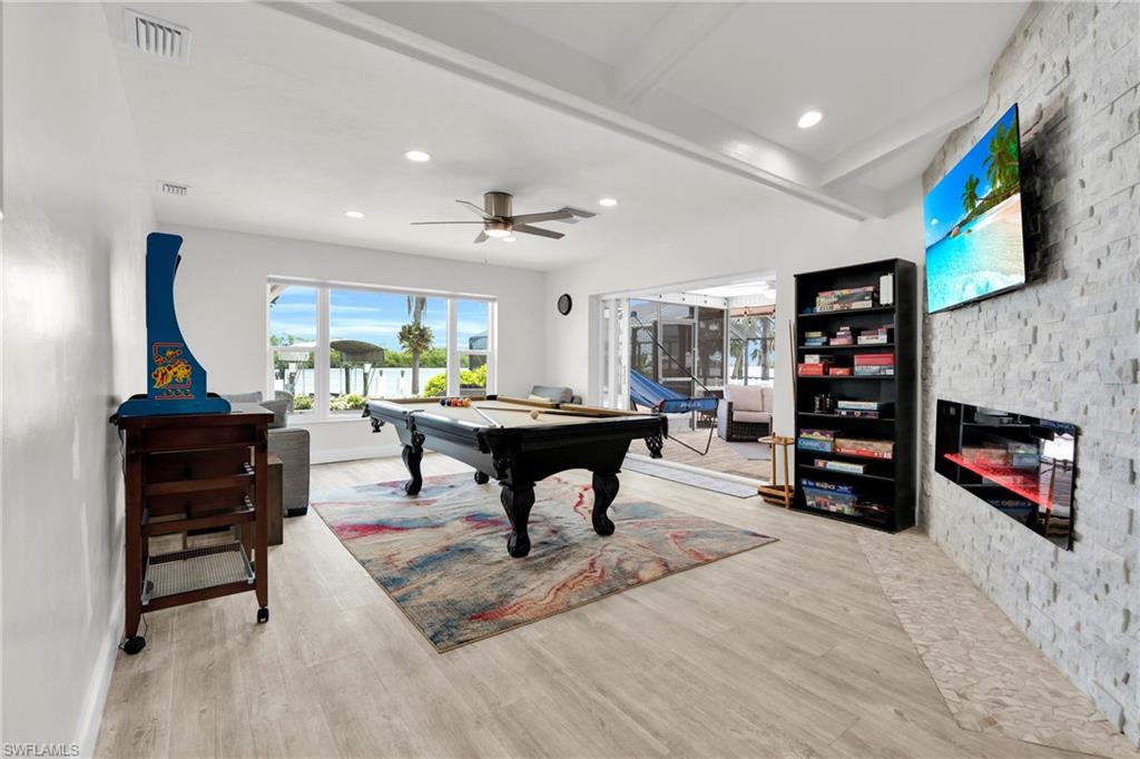 The Family Room/Game Room Has A Stone Walled Fireplace, Triple Hurricane Slider That Leads Out To The Covered Lanai/Pool Area, And A Large Picture Window With An Amazing View Of The River!