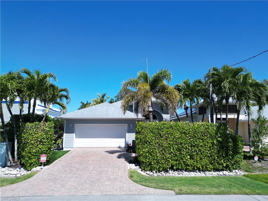 Coastal-style residence with a light gray facade and a white garage door