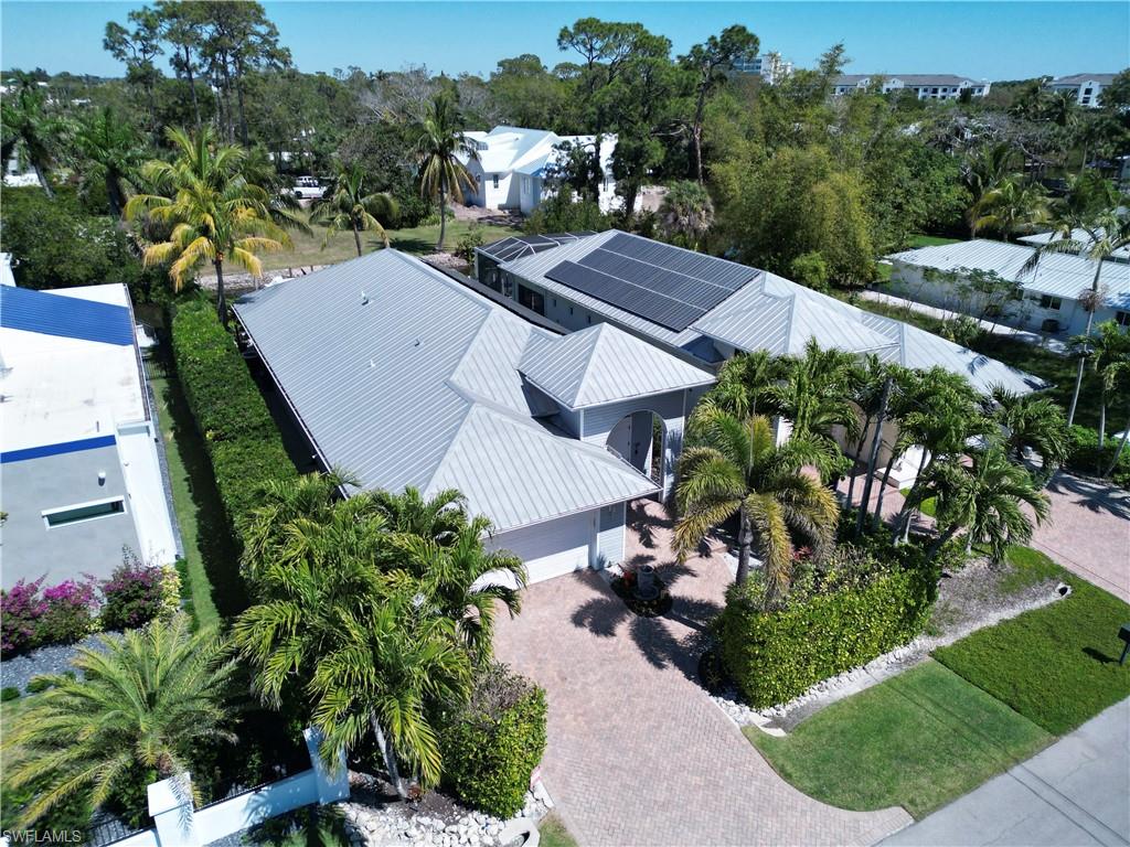 Contemporary single-story residence with a light gray exterior and a standing seam metal roof