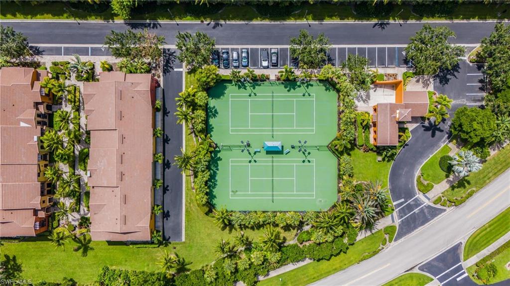 Aerial perspective showcasing two tennis courts with surrounding green landscaping