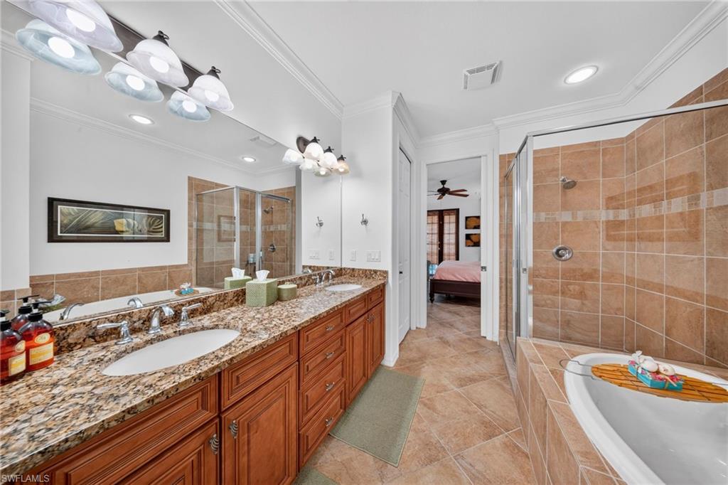 Bathroom featuring a dual vanity with a patterned countertop, dual undermount sinks, and chrome faucets