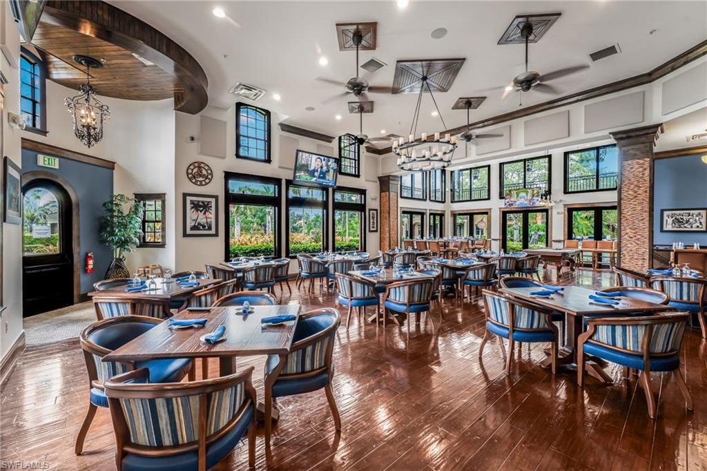 Spacious dining room featuring high ceilings, wood-finish flooring, and expansive windows