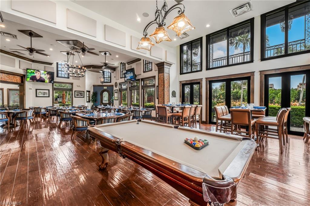 Spacious entertainment area featuring a billiard table, wood-finish flooring, and multiple seating arrangements