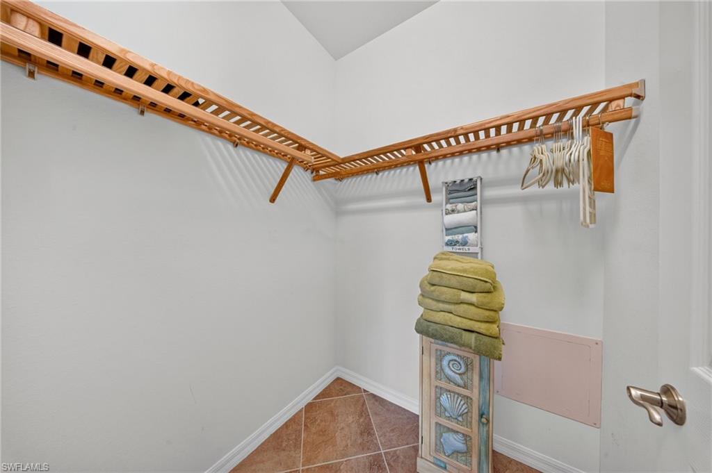 Walk-in closet with natural wood slatted shelving and robust hanging rods
