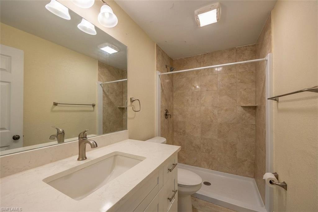 Bathroom featuring a single vanity with an integrated sink, brushed nickel faucet, and light-toned countertop