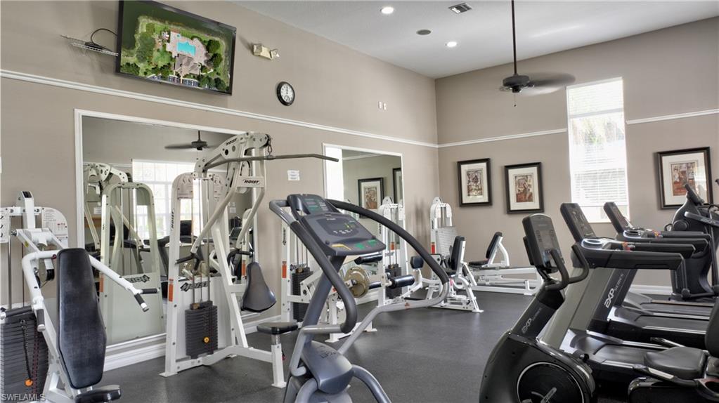 Fitness center featuring neutral wall tones, crown molding, and recessed lighting