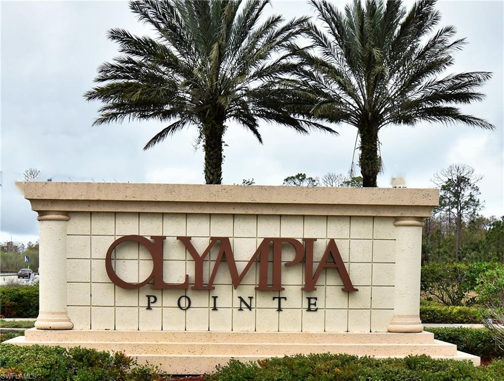 Olympia Pointe community entrance sign featuring decorative blockwork, columnar accents, and prominent metal lettering