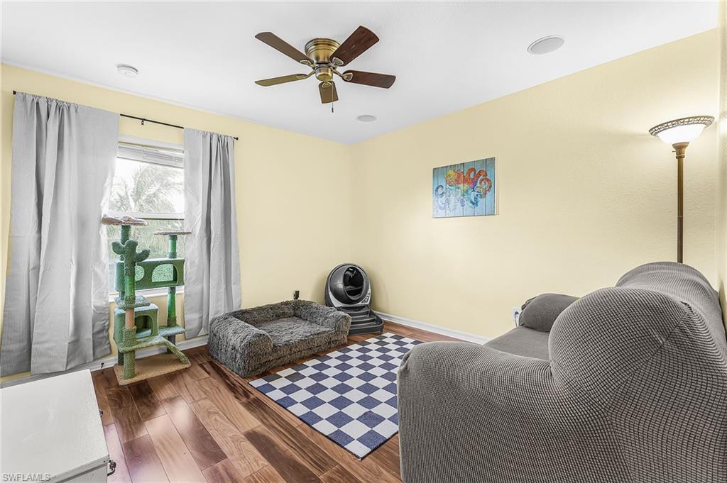 Guest bedroom features wood floors, ceiling fan, views of the lake.