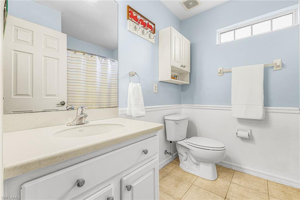 The guest bath has tile floors, fresh paint and clap board accents, tub and shower combo.