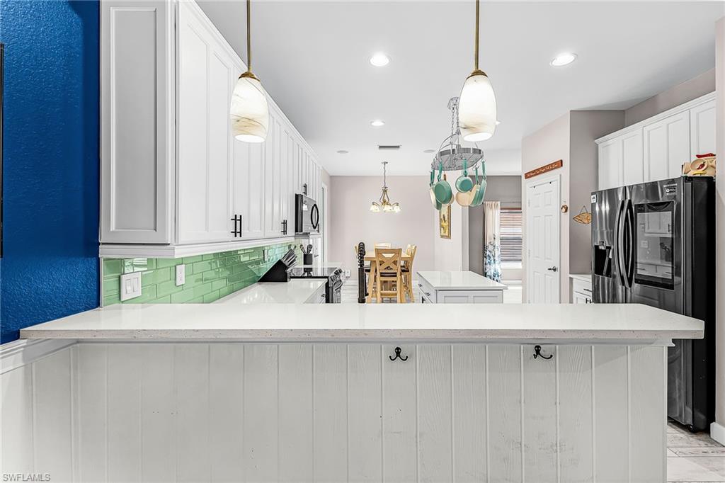 The newly remodeled kitchen features breakfast bar with pendant lighting, 2 pantries, prep island.