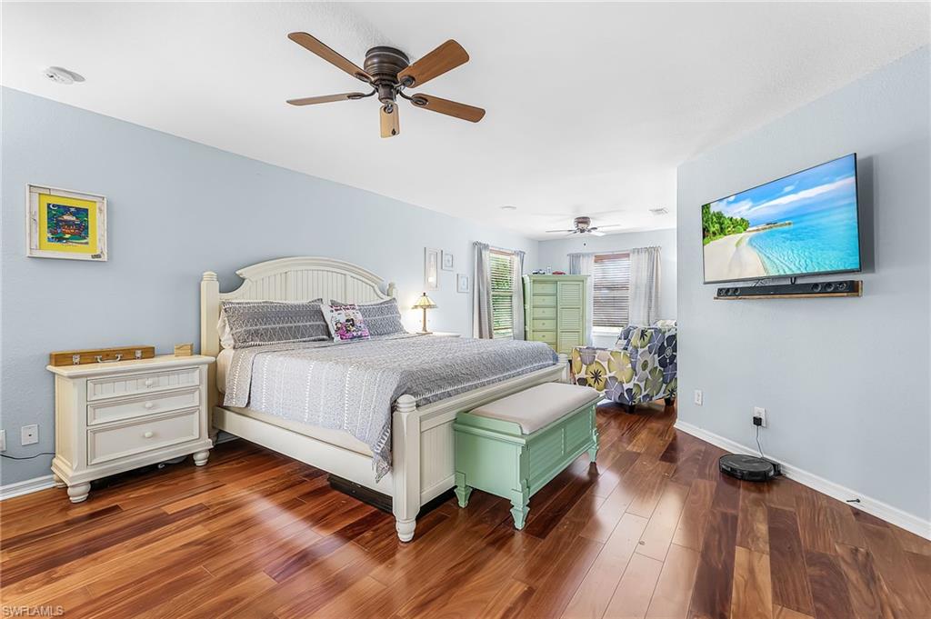 Large owner's suite features wood floors, ceiling fans, sitting area.