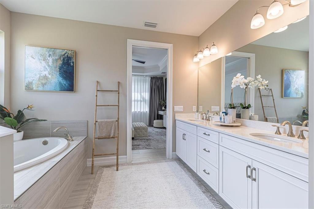 Bathroom with double vanity, a garden tub, and connected bathroom