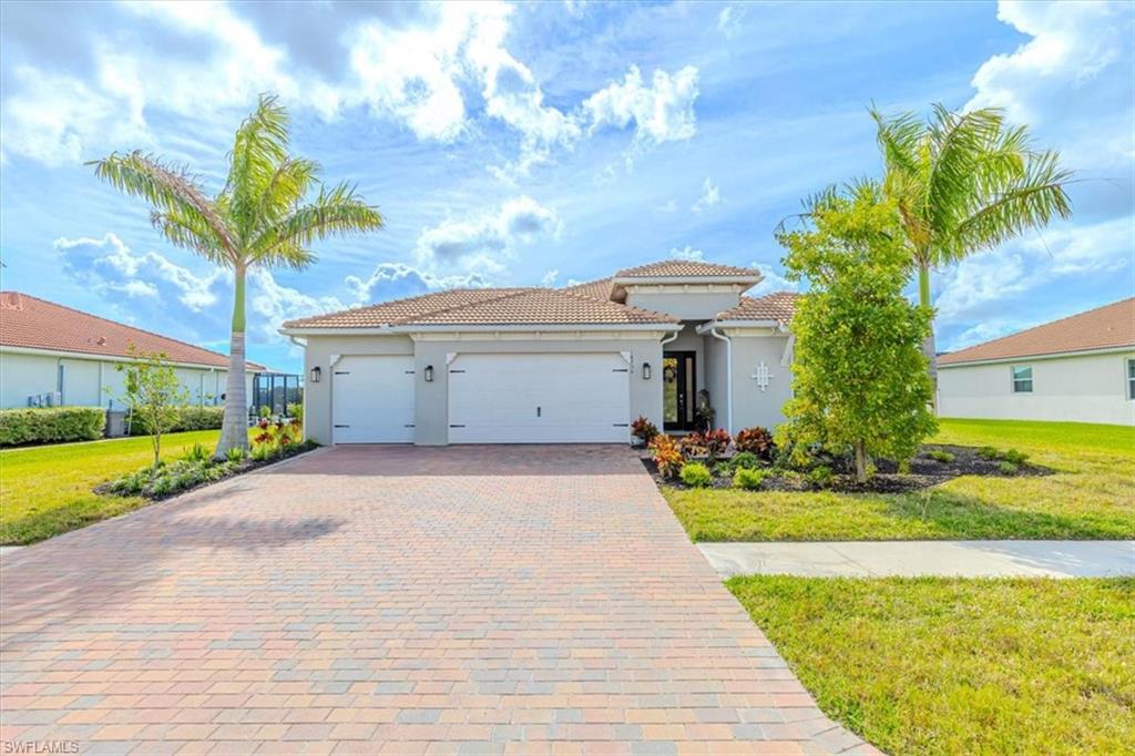 Mediterranean / spanish-style home featuring a front yard, an attached garage, decorative driveway, and stucco siding
