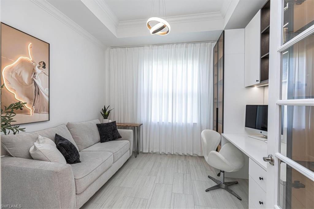 Office area with a raised ceiling and crown molding