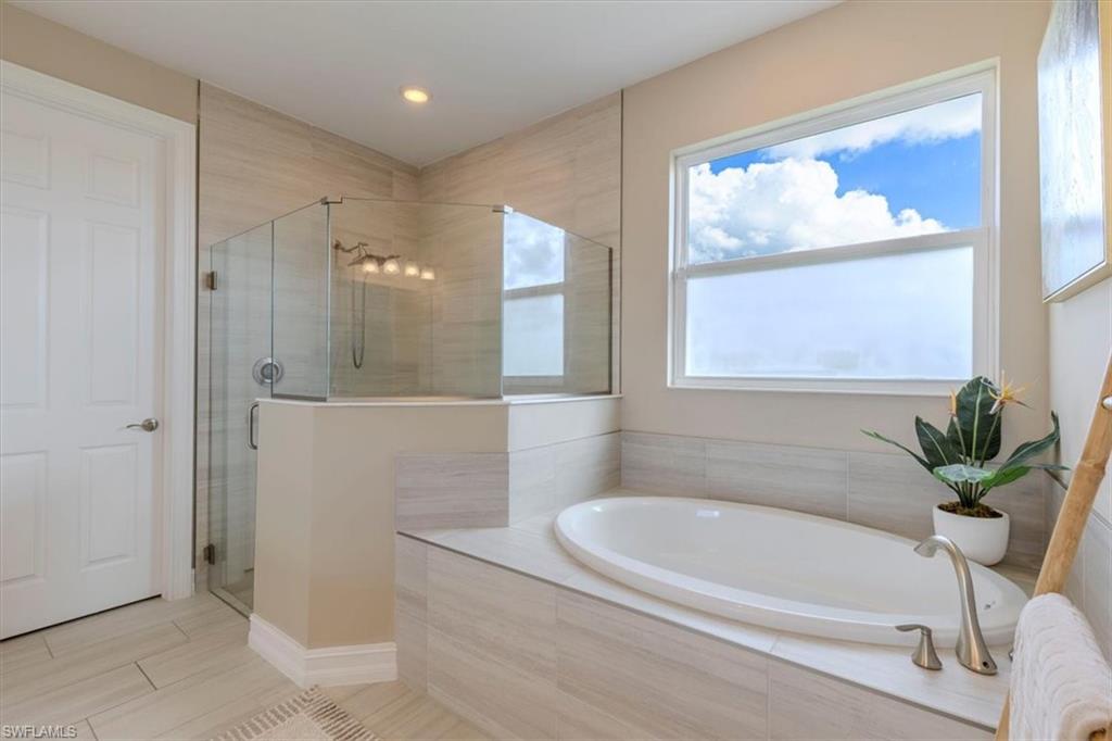 Bathroom featuring a stall shower, a bath, and recessed lighting
