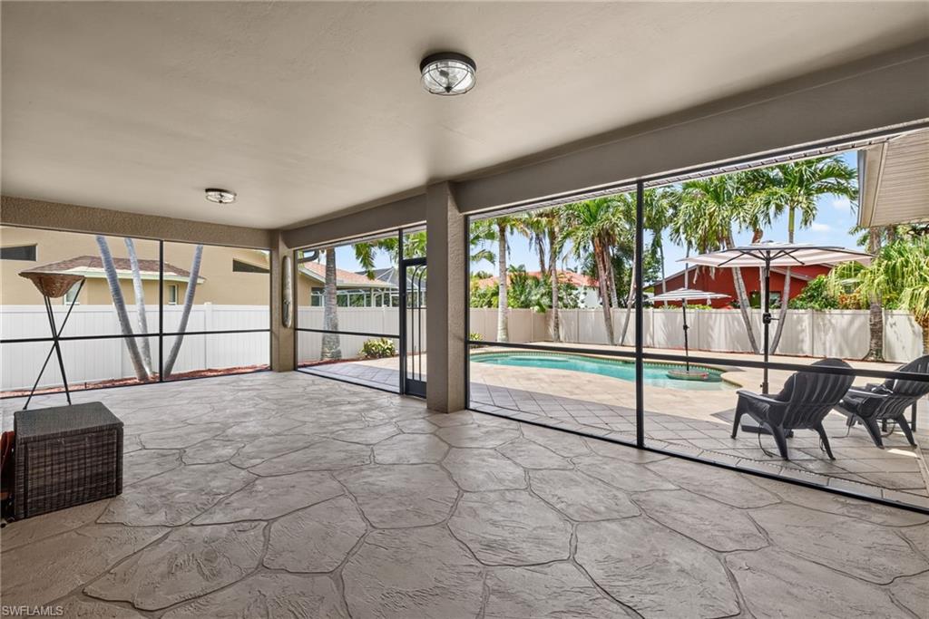 Expansive covered patio featuring stamped concrete flooring and ceiling-mounted light fixtures