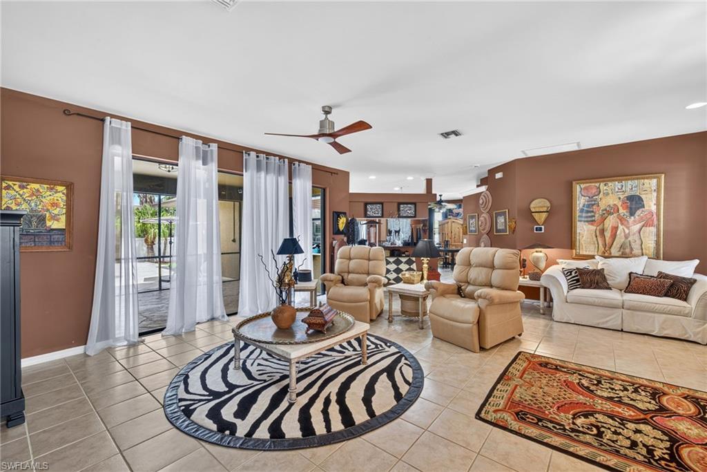 Spacious living area featuring neutral tile flooring and multiple floor-to-ceiling windows