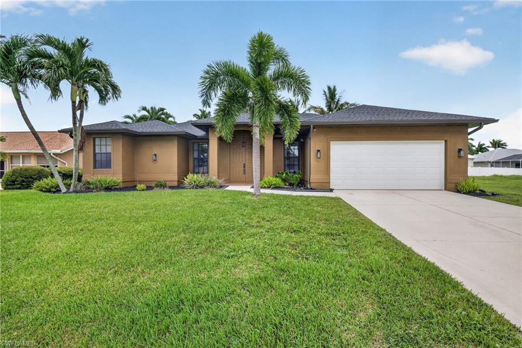 Front exterior featuring a tan stucco finish, dark shingle roof, and a two-car garage