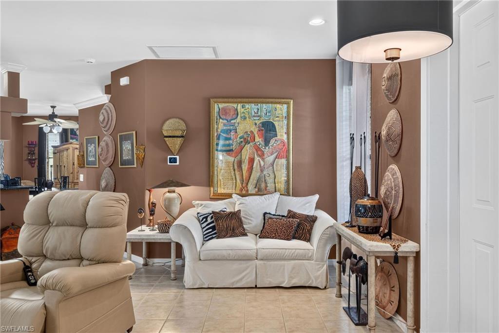 Expansive living area featuring tile flooring, neutral wall tones, crown molding, a ceiling fan, and recessed lighting