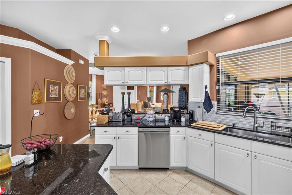 Kitchen featuring white cabinetry, dark granite countertops, stainless steel appliances, a white subway tile backsplash, and recessed lighting