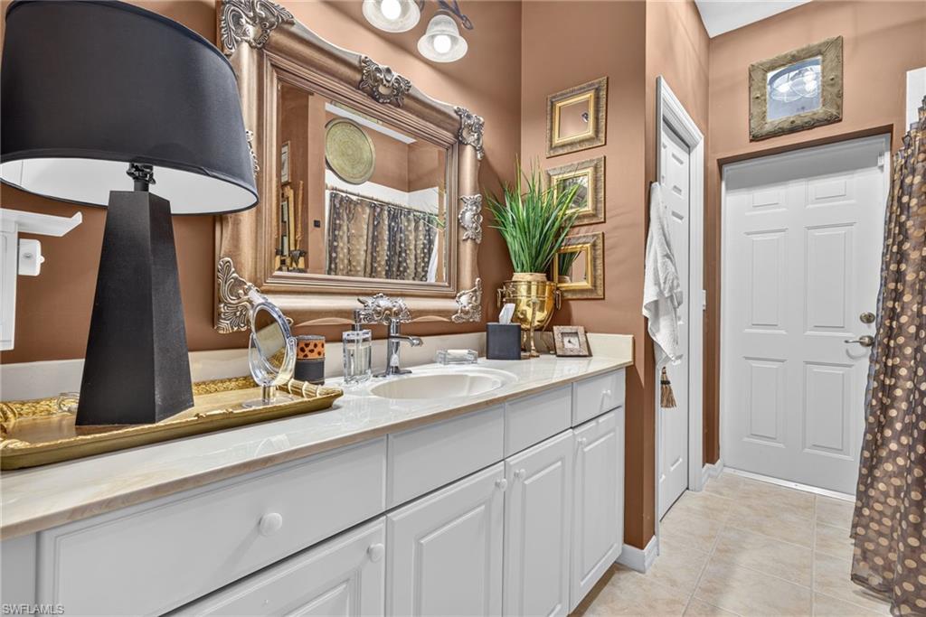 Bathroom featuring a white vanity with panel cabinetry and a light-toned countertop