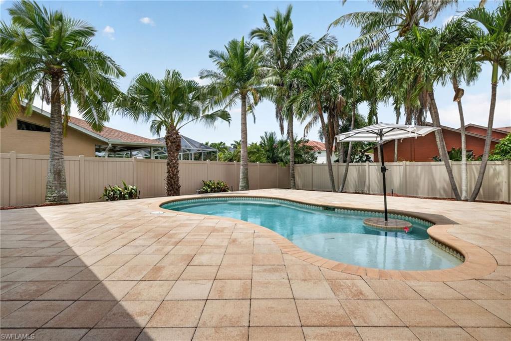Freeform swimming pool with a tile perimeter and expansive paver decking