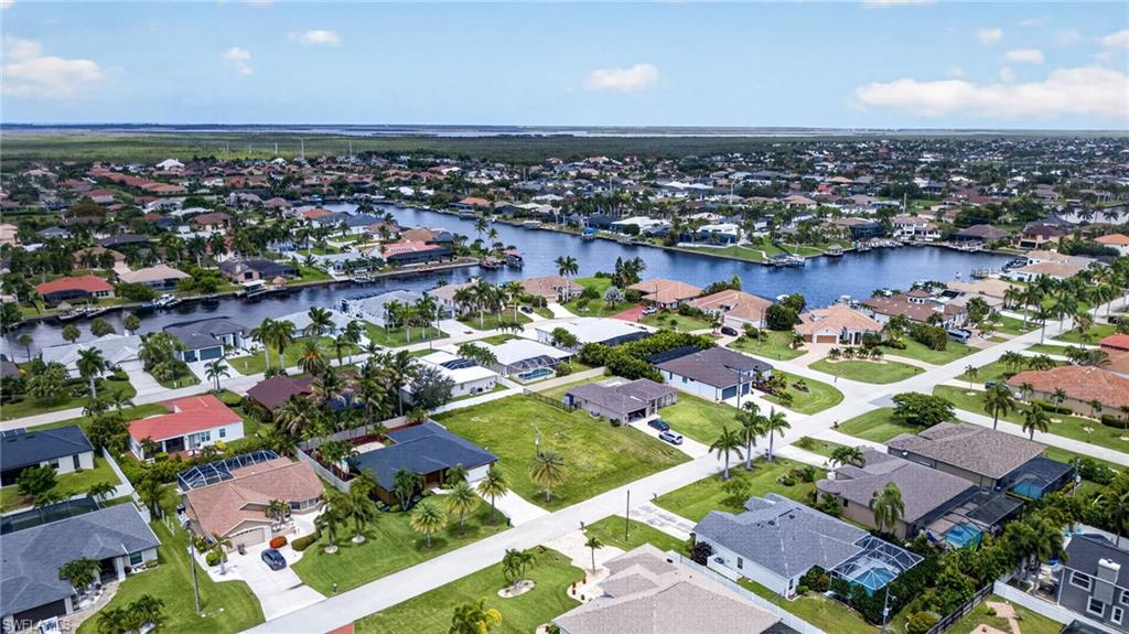 Aerial perspective showcasing a residential community with navigable waterways and numerous properties