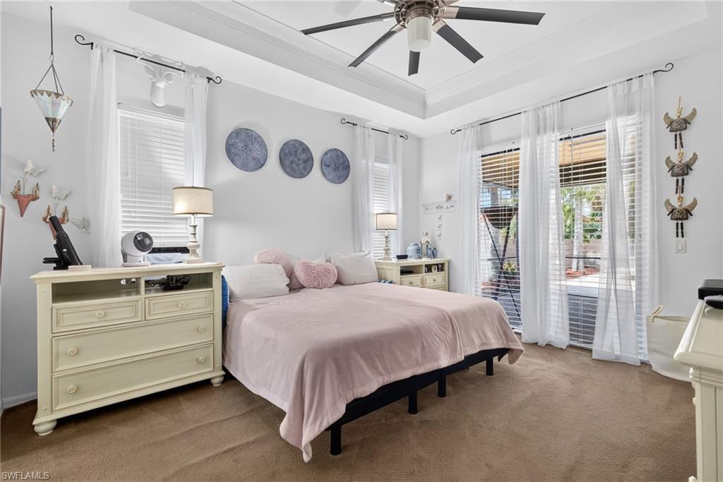 Tray ceiling featuring a ceiling fan with light fixture