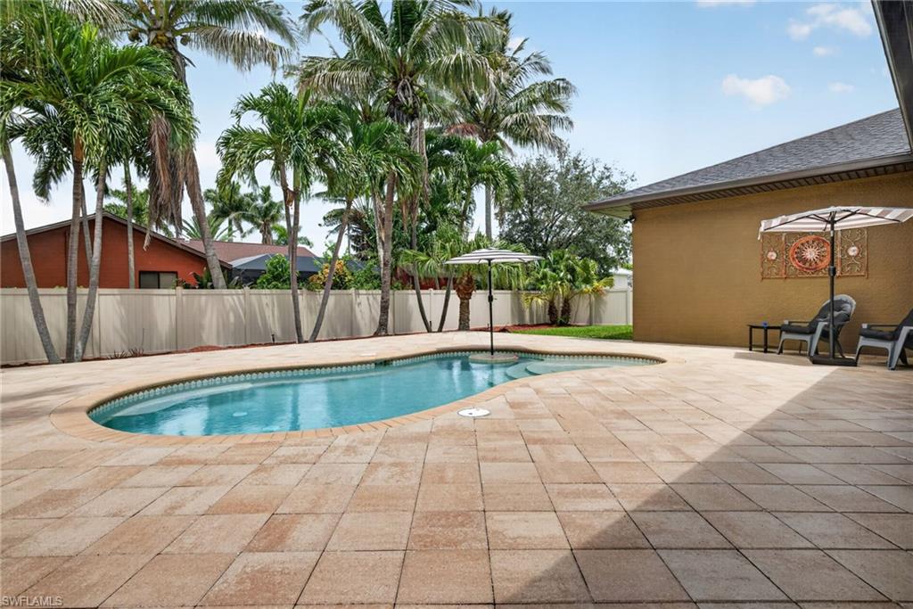 Freeform swimming pool surrounded by a paver deck