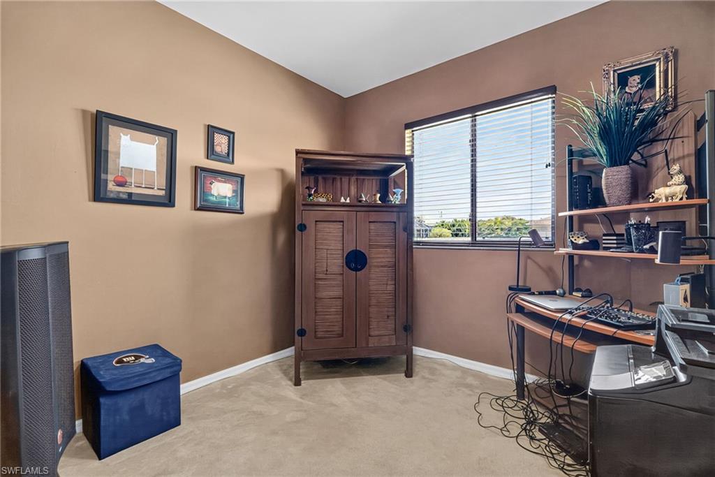 Corner room featuring a window with horizontal blinds, carpet flooring, and neutral-toned walls