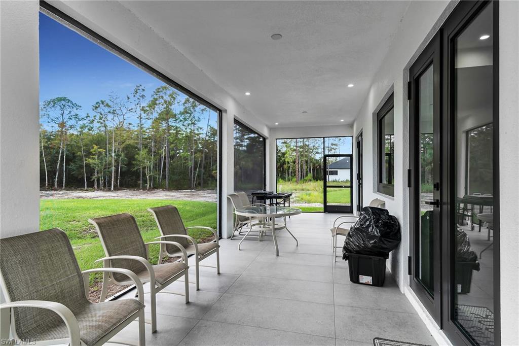 Expansive screened lanai featuring large format tile flooring and recessed lighting