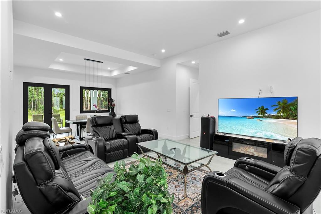Open-concept living space featuring high ceilings, recessed lighting, and light-tone flooring