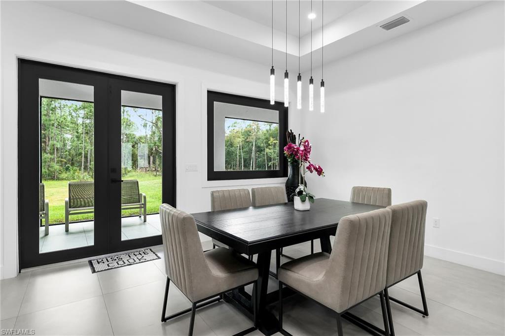 Dining area featuring large format tile flooring and a multi-pendant lighting fixture
