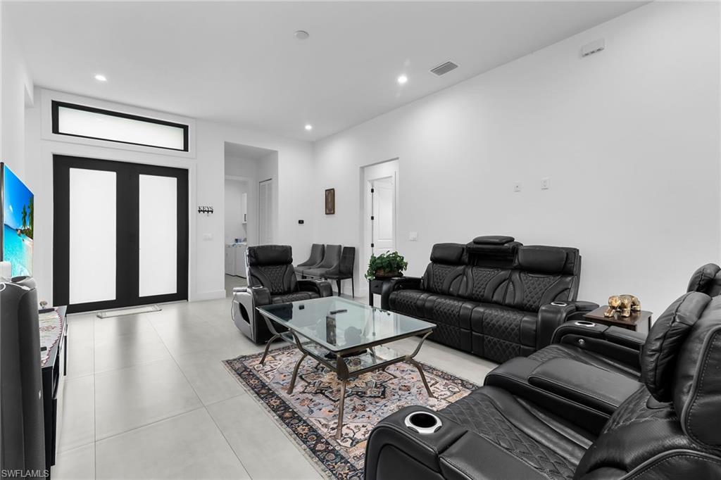 Entry foyer featuring a transom window above double entry doors with frosted glass panels