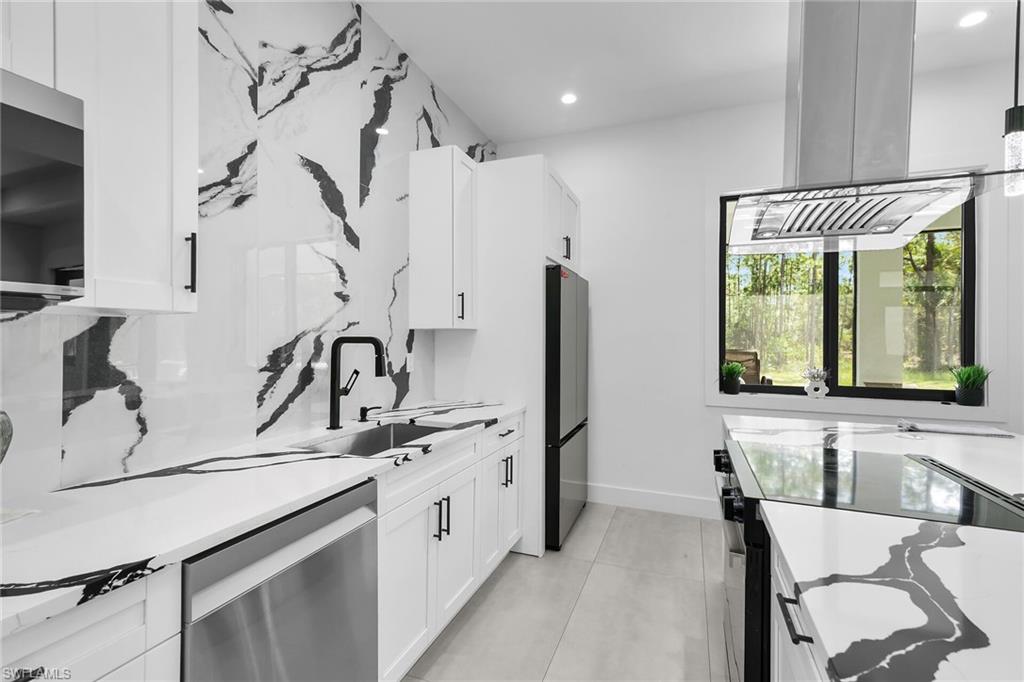 Contemporary kitchen featuring sleek white cabinetry, black hardware, and patterned countertops with a matching backsplash