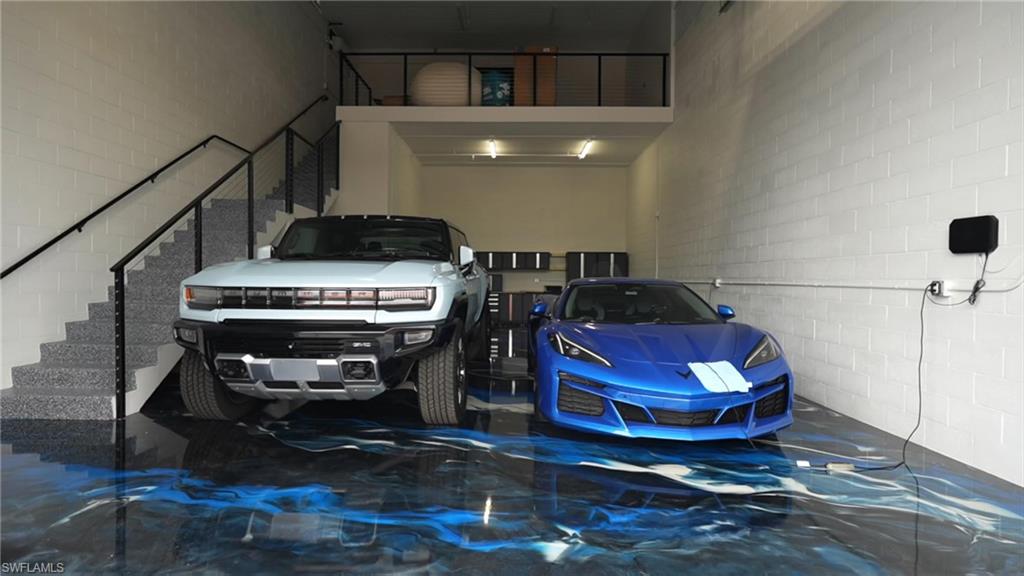 Two-story garage space featuring a striking blue and black epoxy floor
