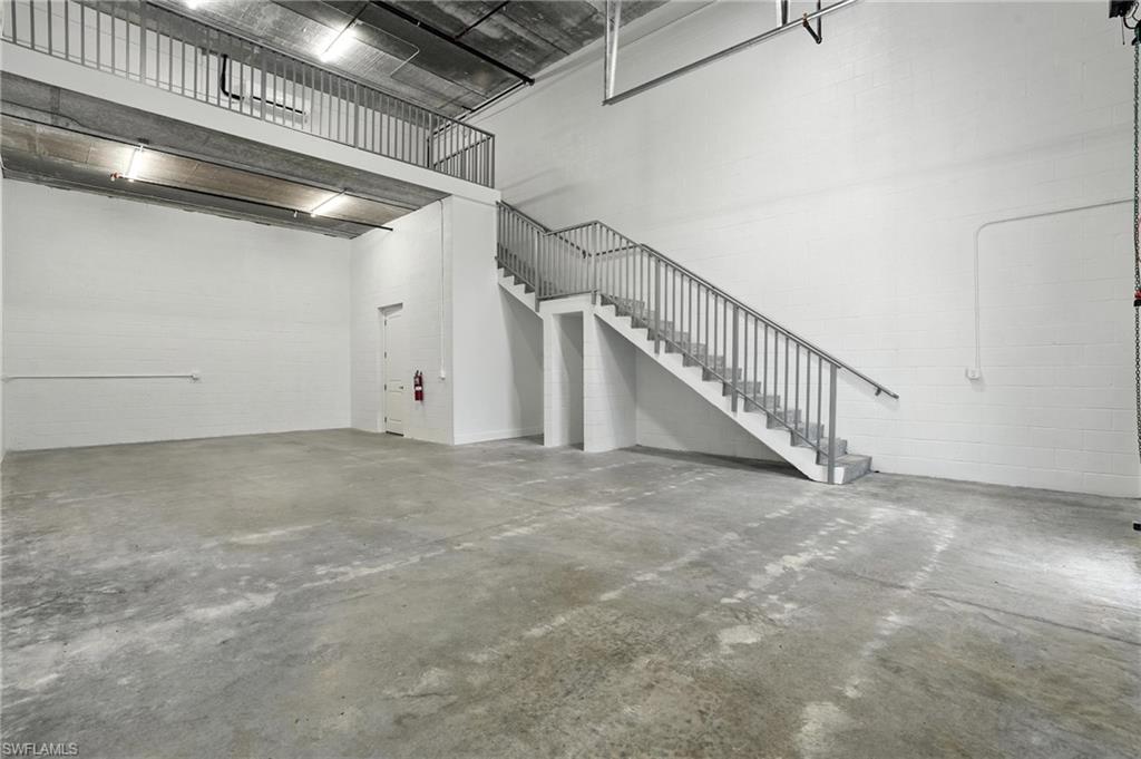 Expansive open floor plan with concrete flooring, high ceilings, and exposed overhead ductwork