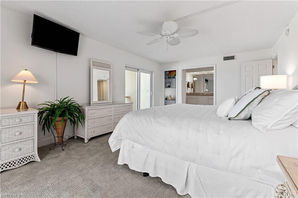 Bedroom featuring carpeting, a ceiling fan, wall-mounted television, and direct access to a private balcony