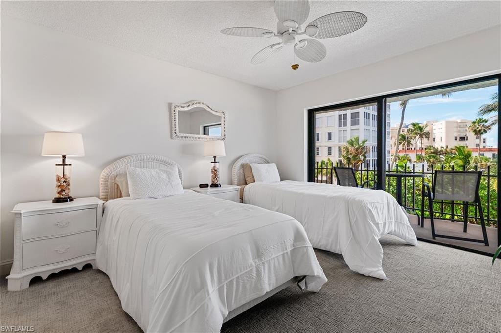 Bedroom featuring a private balcony, sliding glass doors, ceiling fan, and carpeted flooring