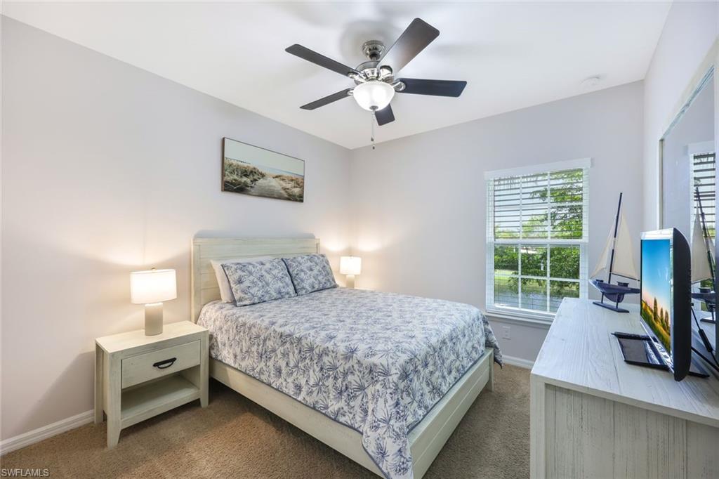 Carpeted bedroom featuring ceiling fan
