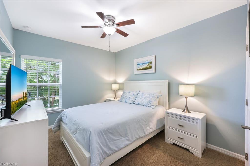 Bedroom featuring multiple windows, ceiling fan, and dark carpet
