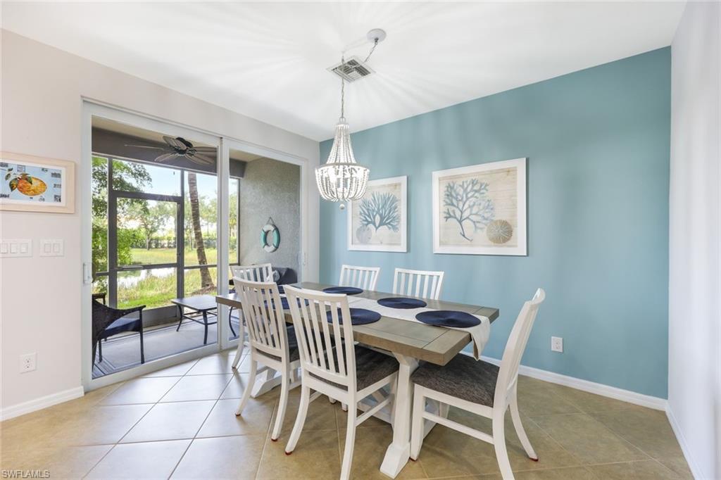 Tiled dining area with ceiling fan with notable chandelier